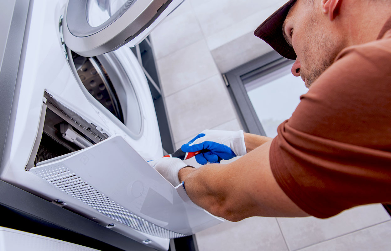A man deep cleaning a dryer
